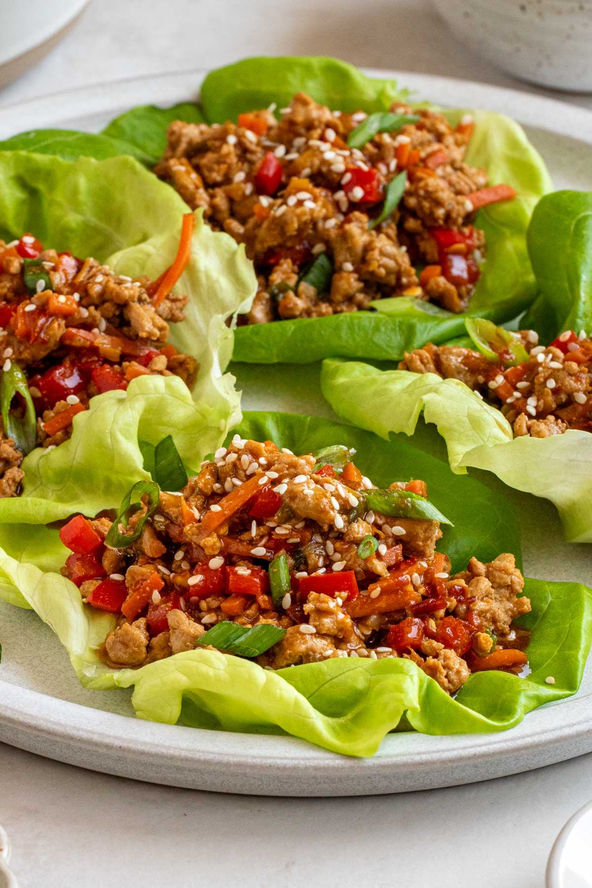 Close up of an Asian chicken lettuce wrap on a plate.