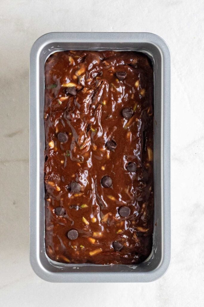 Raw chocolate zucchini bread batter in a loaf pan. 