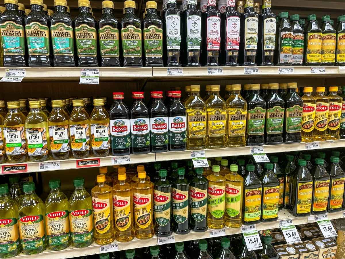 Bottles of cooking oils on grocery store shelves.