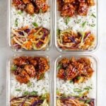 Four sticky chicken meal prep bowls in glass containers on a white background.