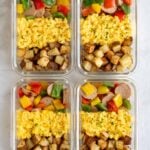 Four healthy meal prep breakfast bowls in glass containers on a white background.