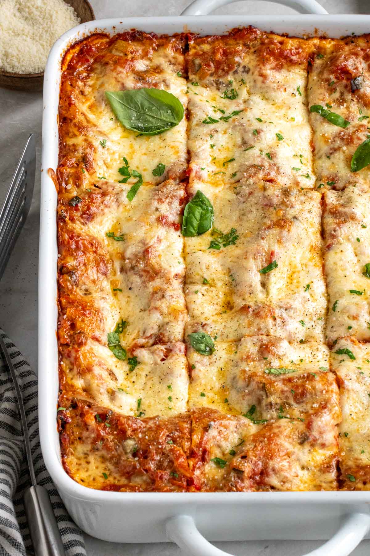 Close up of vegetarian lasagna in a white casserole dish.