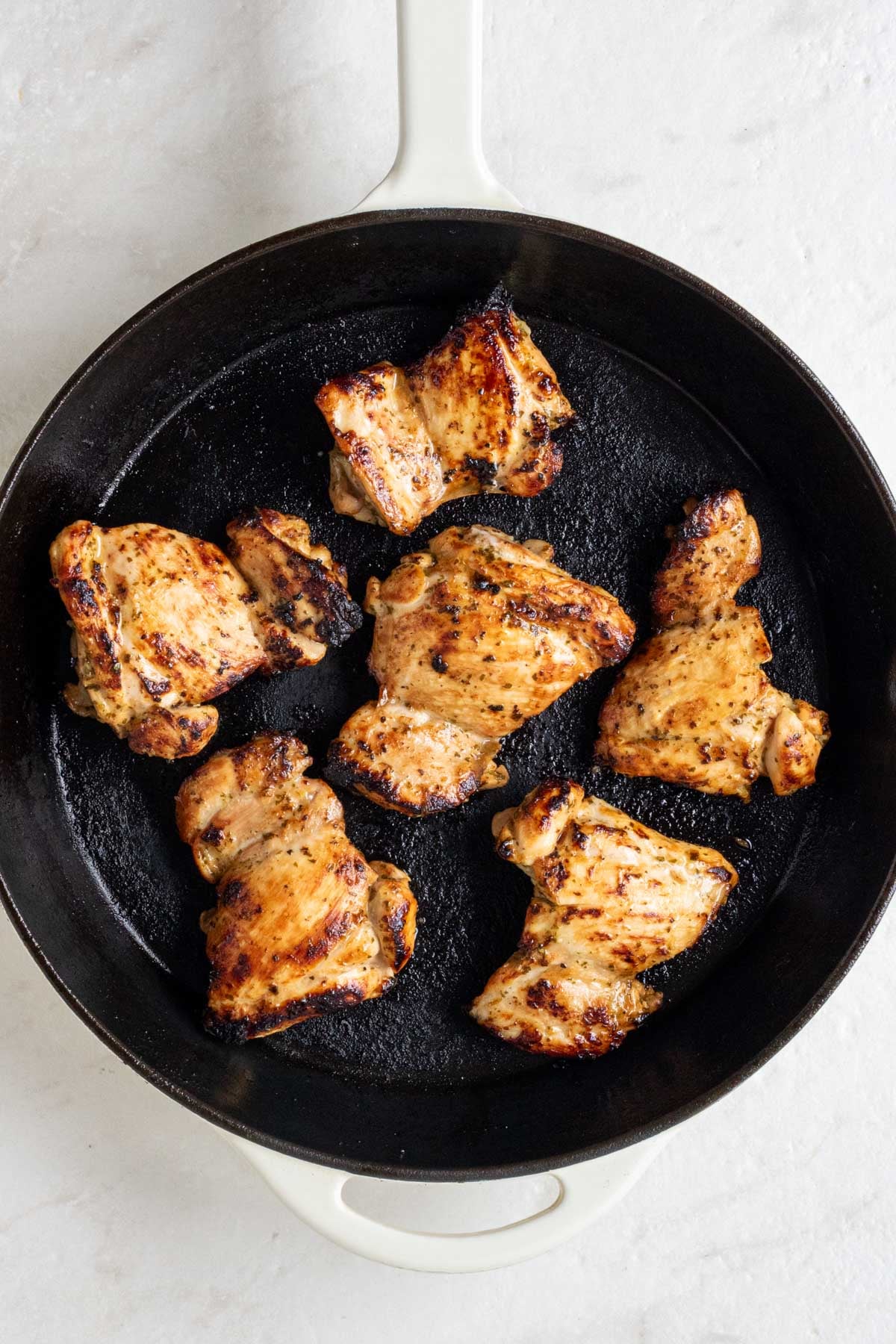 Cast iron skillet with cooked cilantro lime chicken thighs.