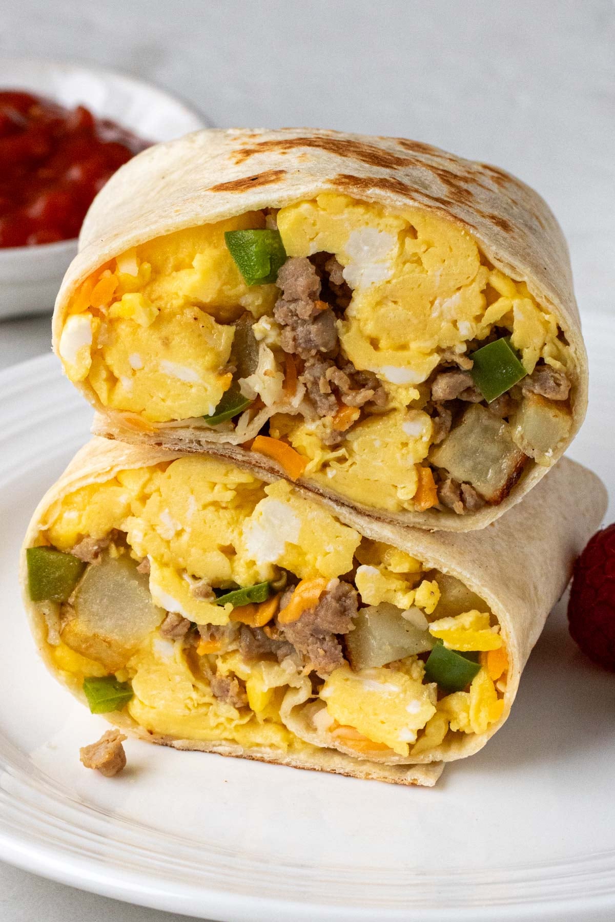 Close up of a make-ahead breakfast burrito on a white plate.