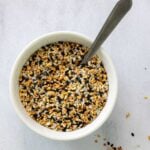 Small white bowl with everything bagel seasoning and a spoon.