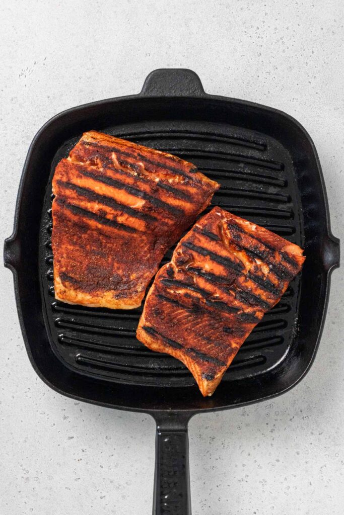 Salmon grilling in a cast-iron grill pan.