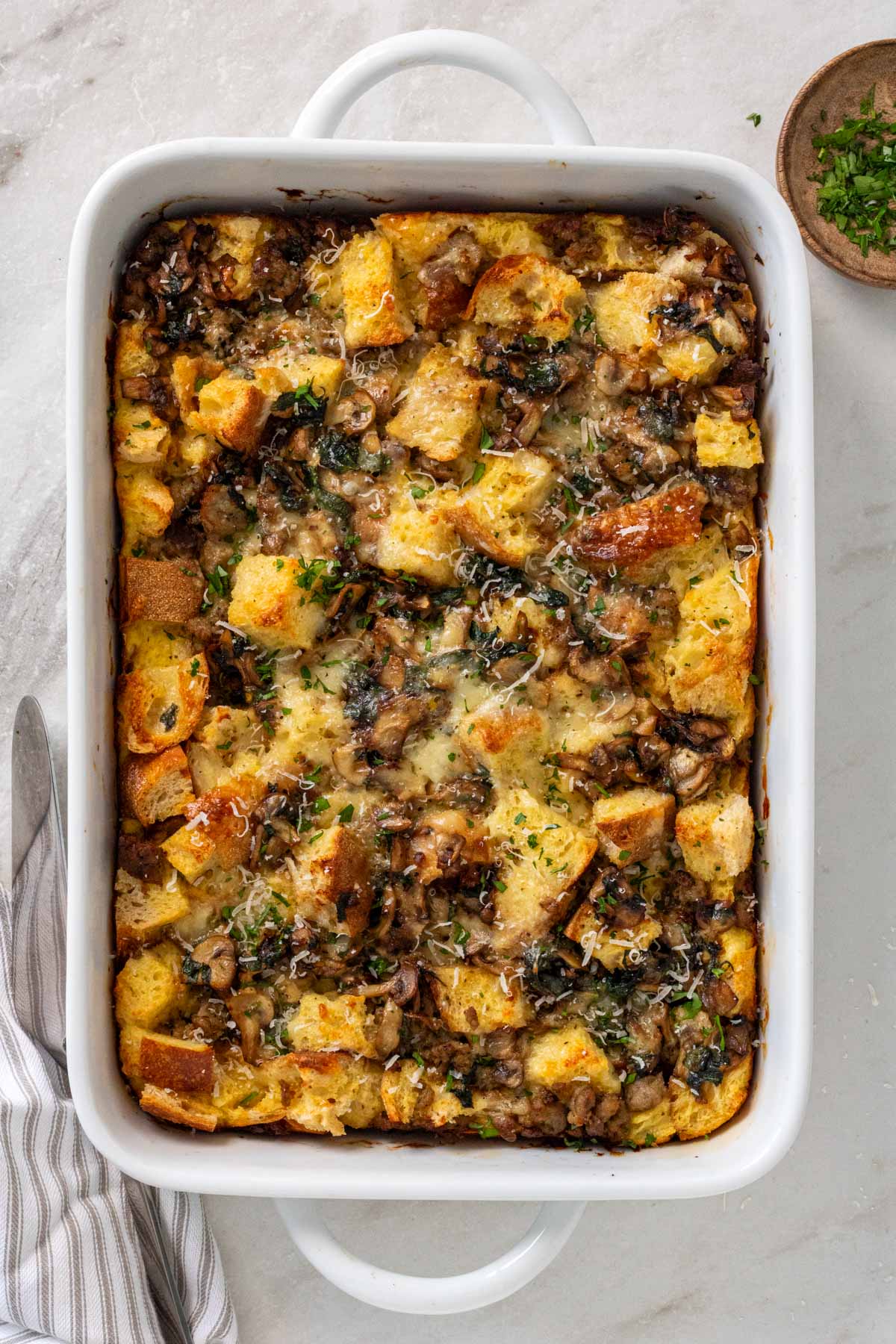 Baking dish with egg, sausage, and bread breakfast casserole. 