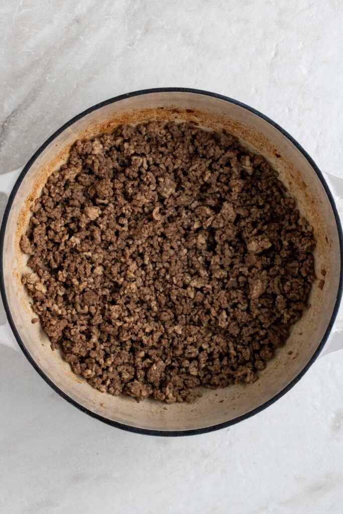Large pot with cooked ground beef and ground pork. 