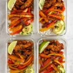 Four glass containers of chicken fajita meal prep bowls.