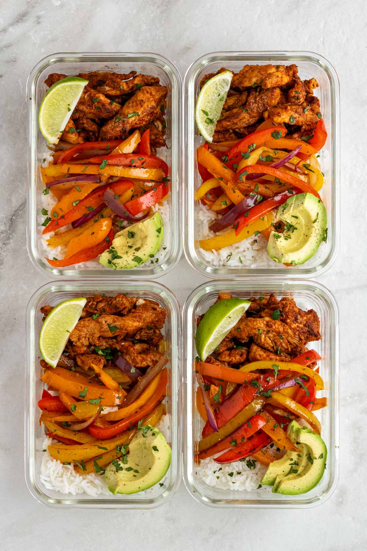 Four glass containers of chicken fajita meal prep bowls.