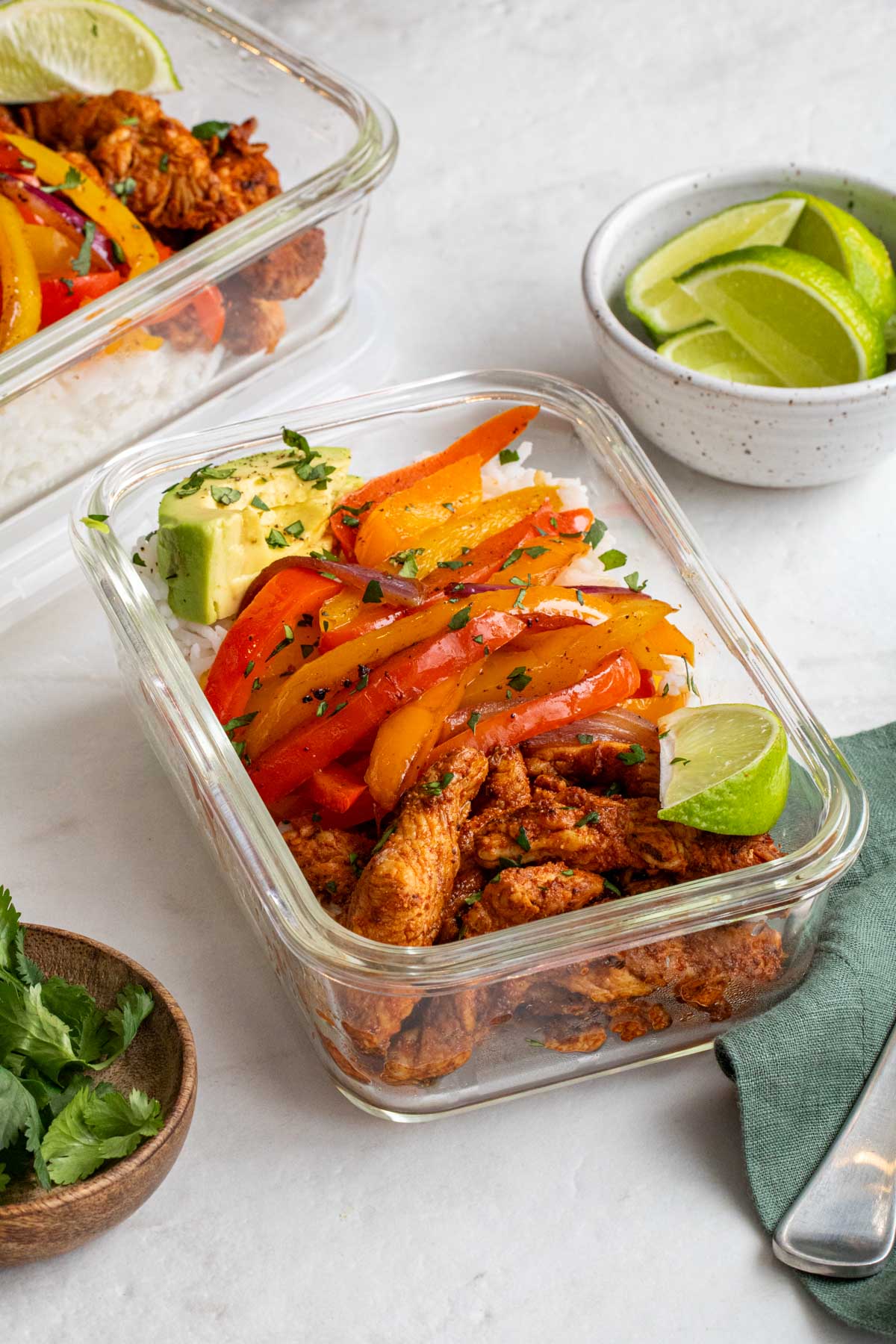Close up of meal prep chicken fajita bowls in glass meal prep containers. 