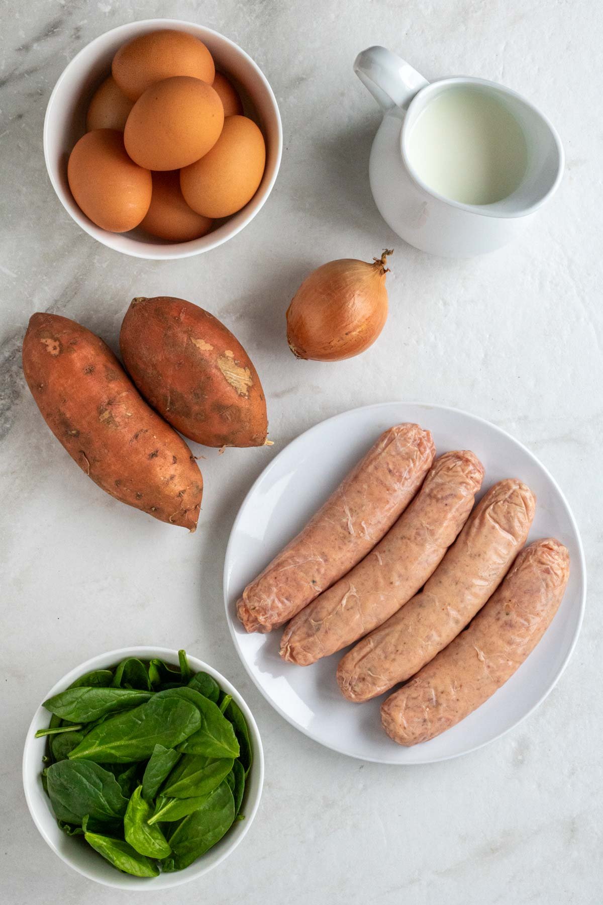 Ingredients for sausage sweet potato frittata: pork sausage, sweet potatoes, onion, spinach, eggs, milk, salt, and pepper.