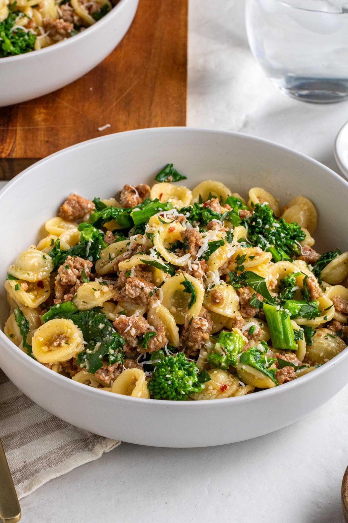Sausage and broccoli rabe pasta in a white bowl.