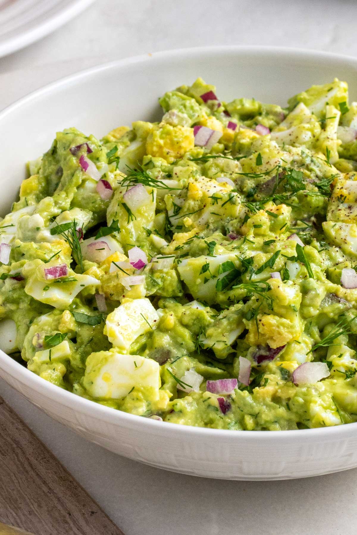 Close up of a bowl of creamy avocado egg salad.