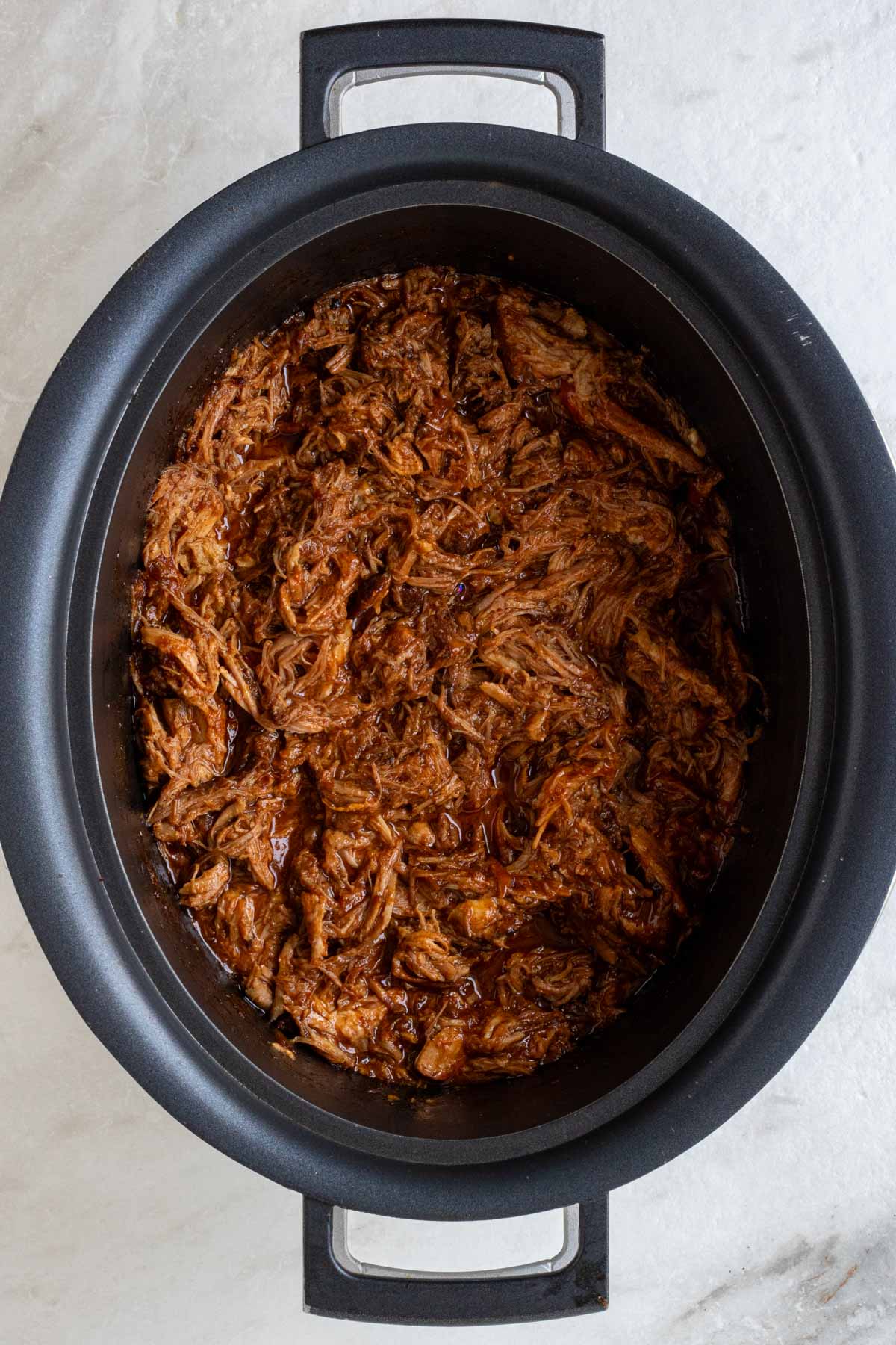 Slow cooker filled with BBQ pulled pork.