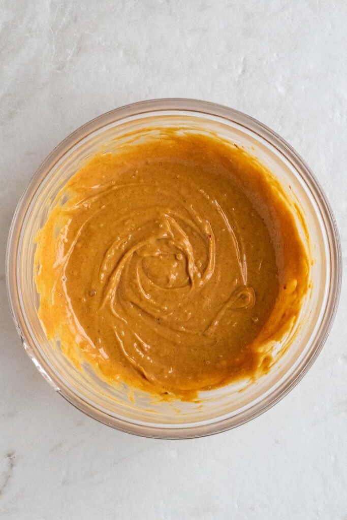 Glass bowl of Thai peanut sauce.