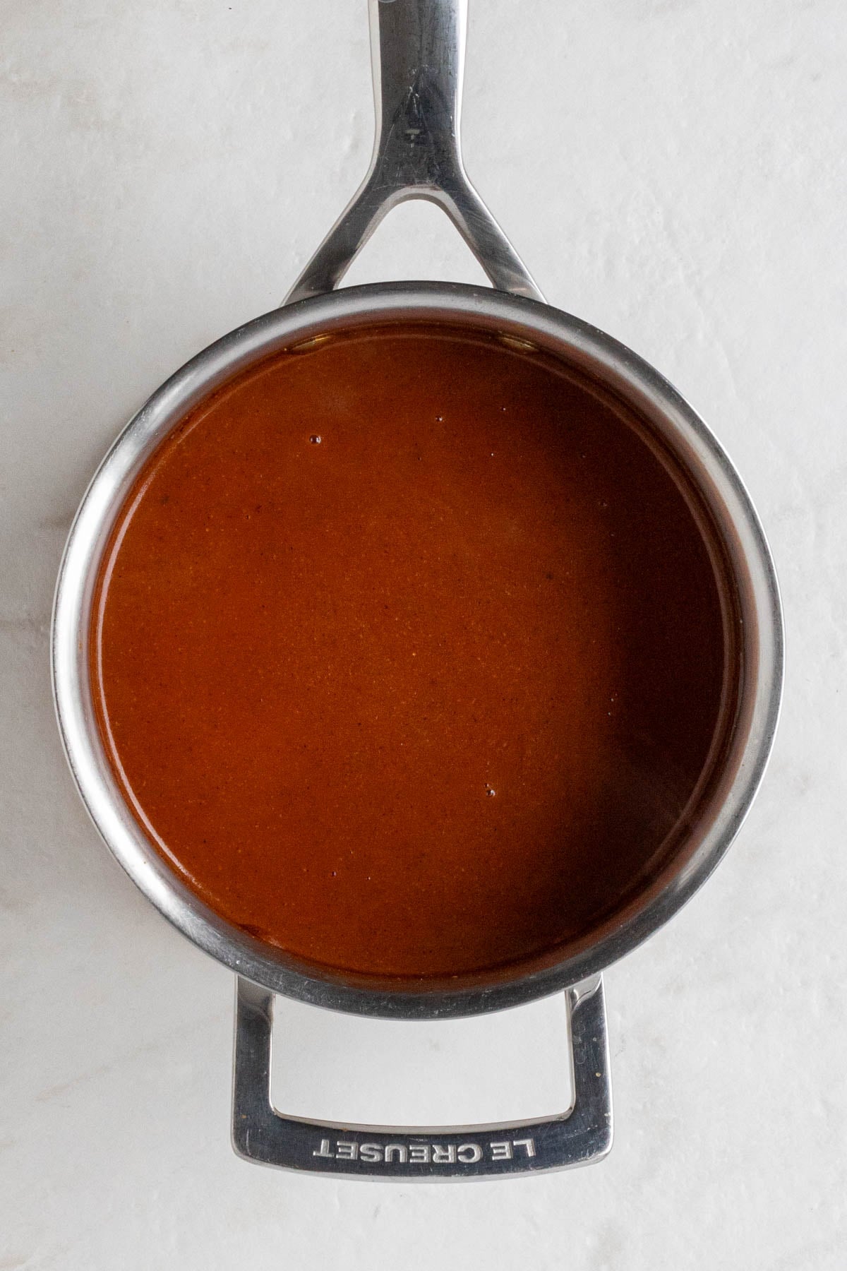Small pot filled with homemade red enchilada sauce.