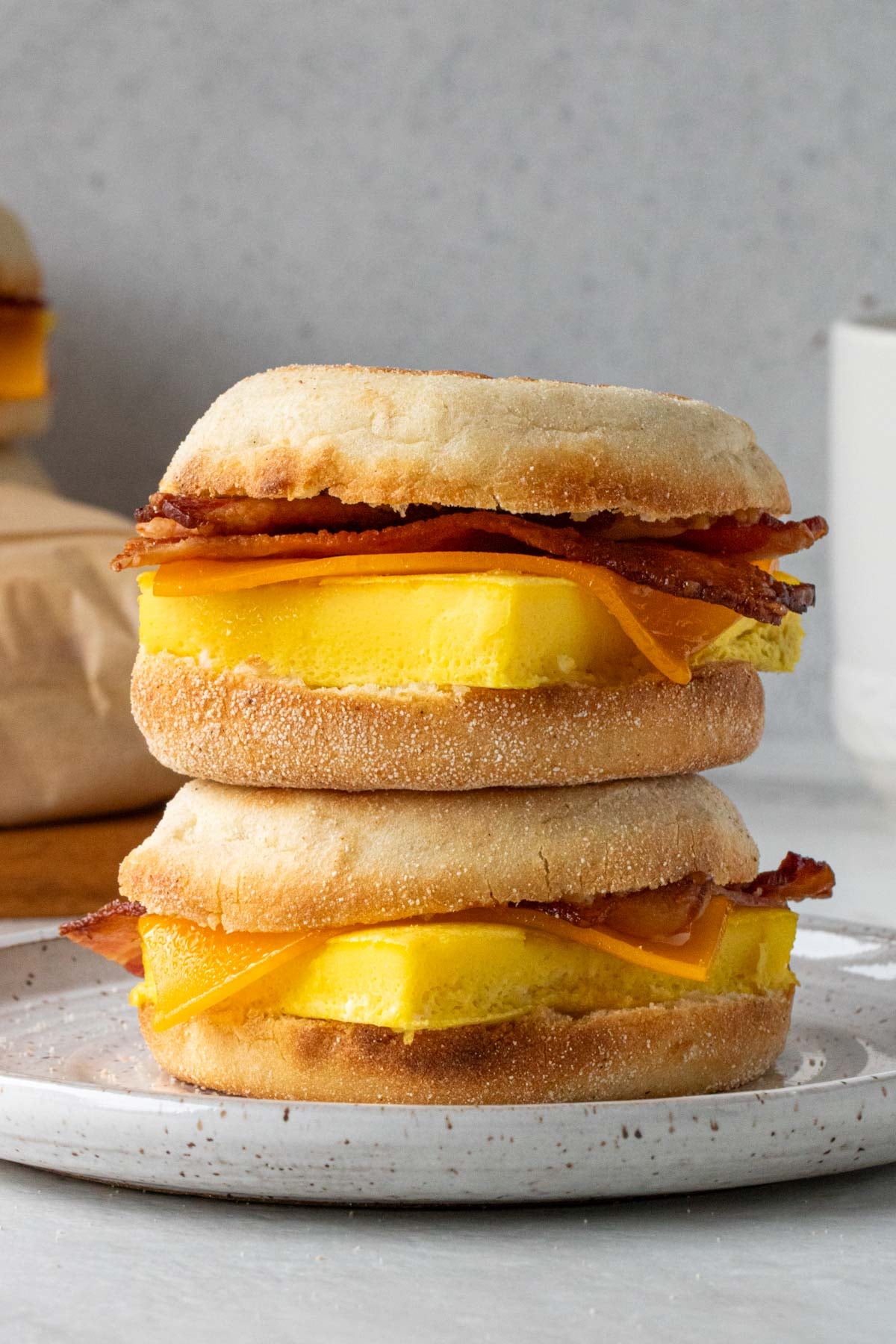 Close up of bacon, egg, and cheese sandwiches on a white background.