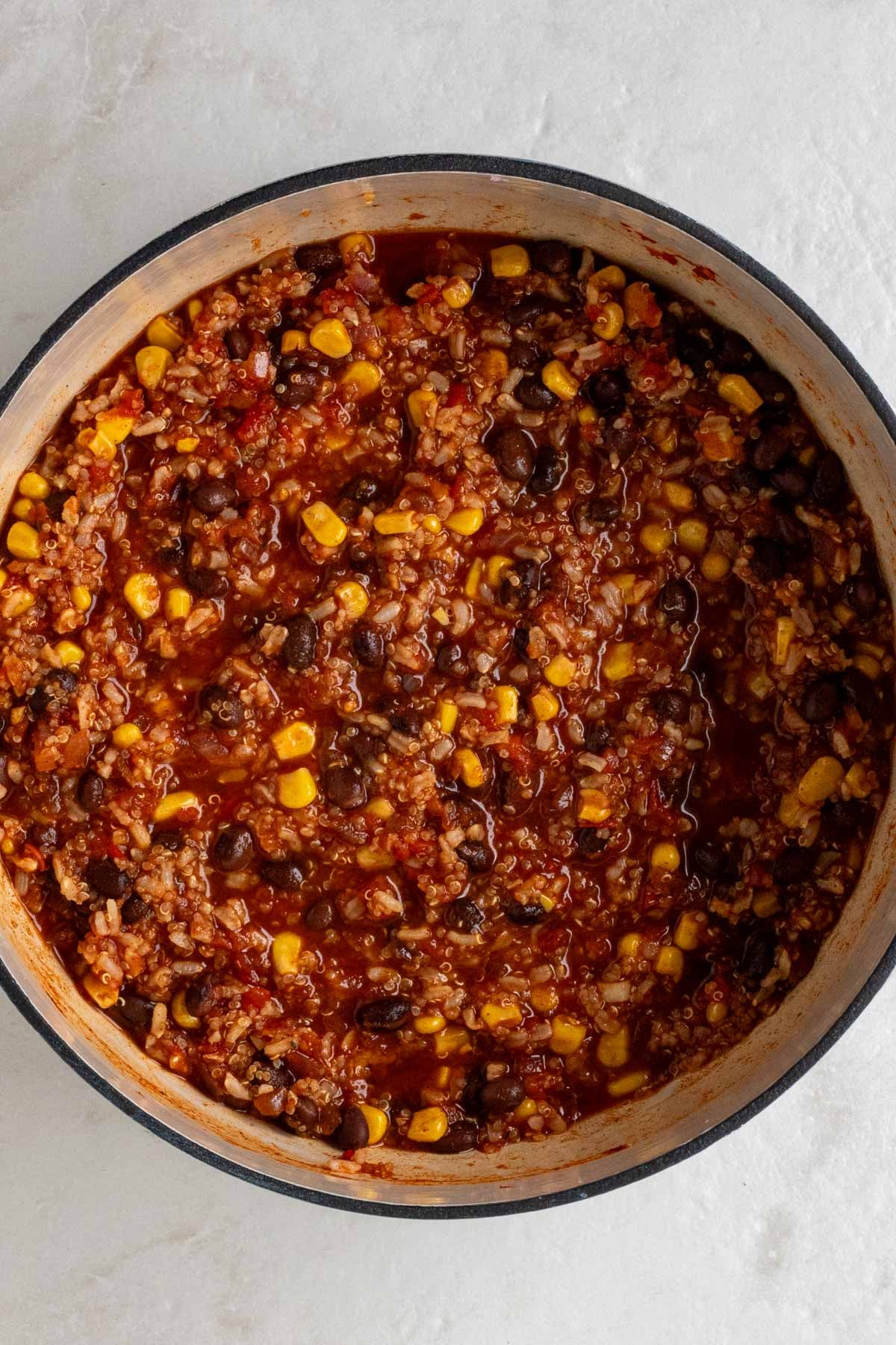 Large pot with brown rice, quinoa, and black bean filling on a white background.