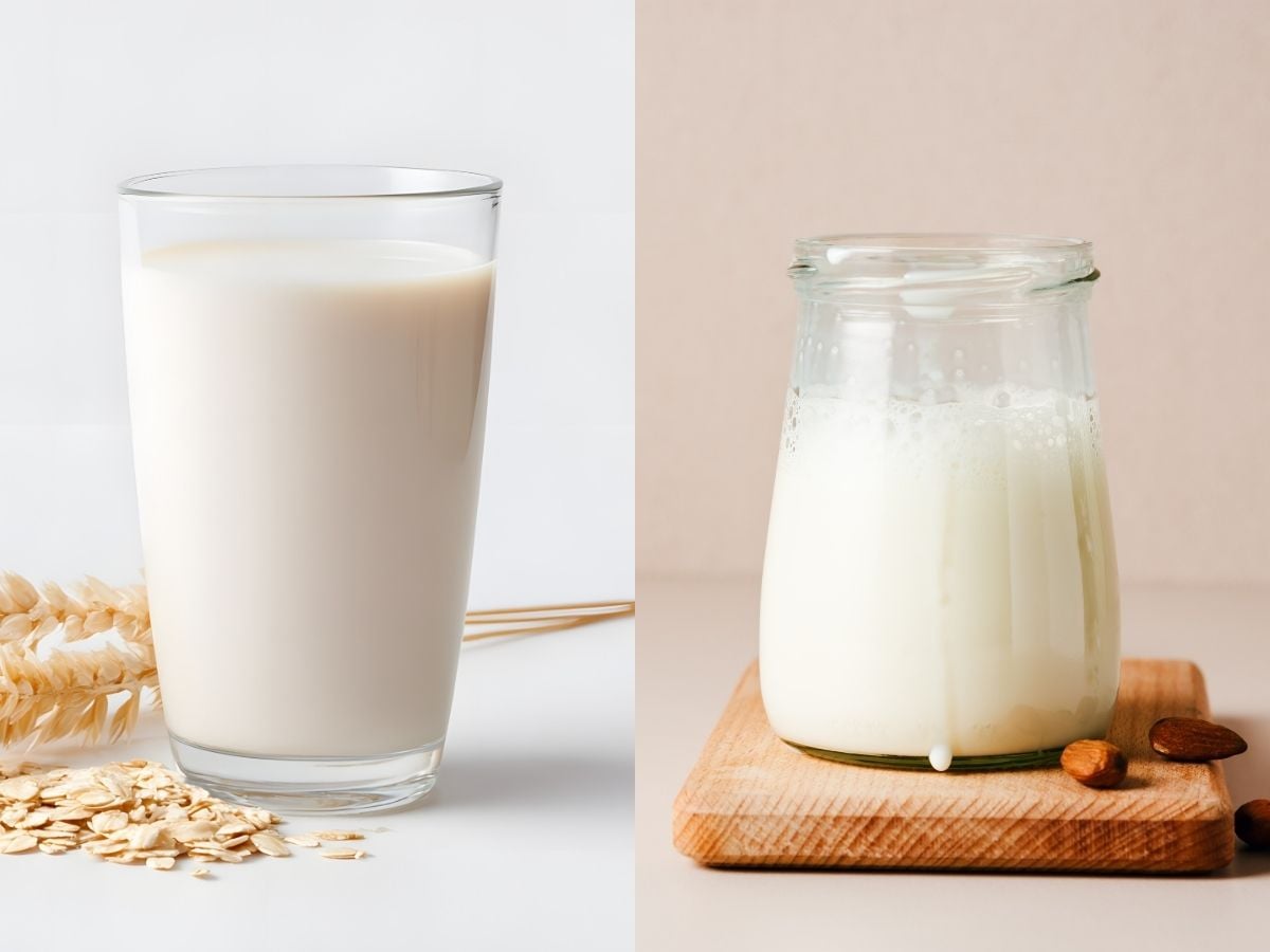 Tall glass of oat milk with rolled oats on the side and an oat straw behind it on a white background, next to a small jar of almond milk on a wood cutting board with whole almond on the side on a pink background.