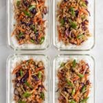 Four meal prep egg roll in a bowl with white rice in glass containers on a white background.