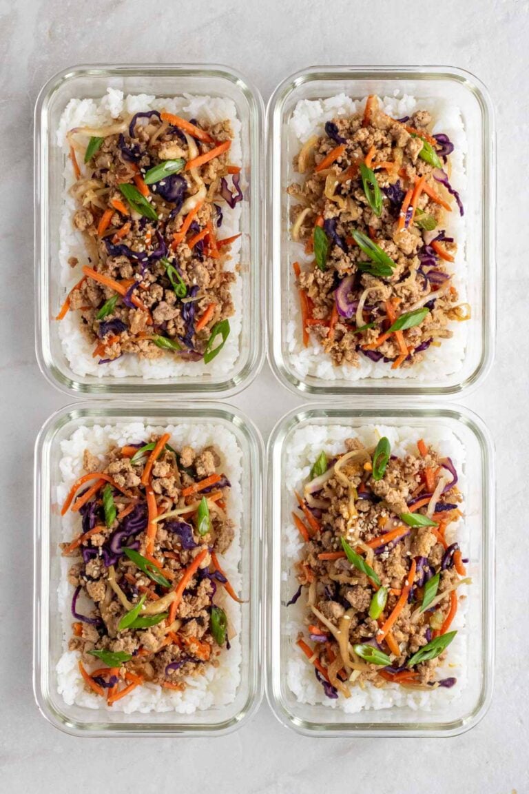 Four meal prep egg roll in a bowl with white rice in glass containers on a white background.