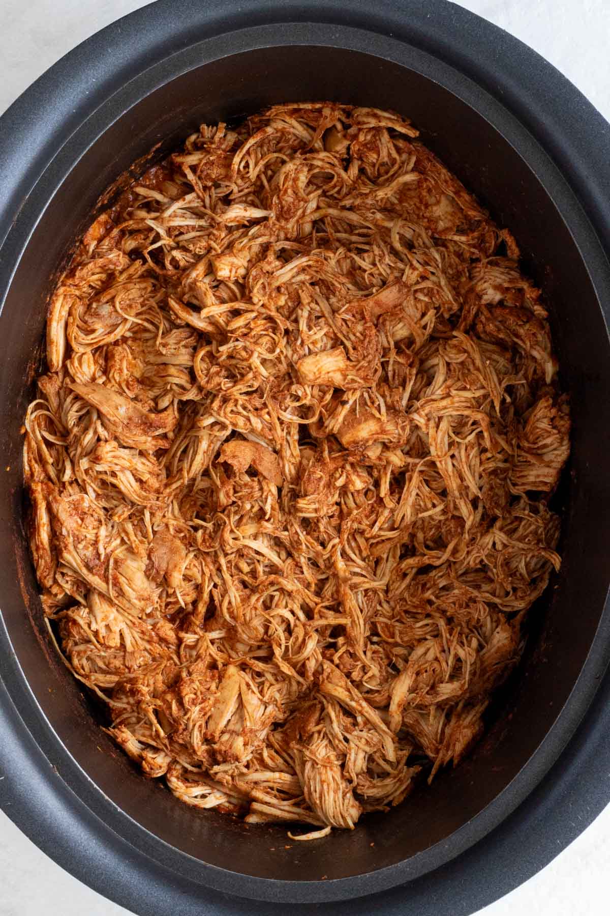 A close of of slow cooked shredded chicken taco meat.