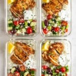 Four glass containers or Greek chicken meal prep bowls on a white background.