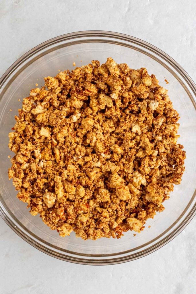 Glass bowl of seasoned crumbled tofu.