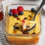 Close up of a protein pancake meal prep bowl with maple syrup on top with a spoonful on a spoon.