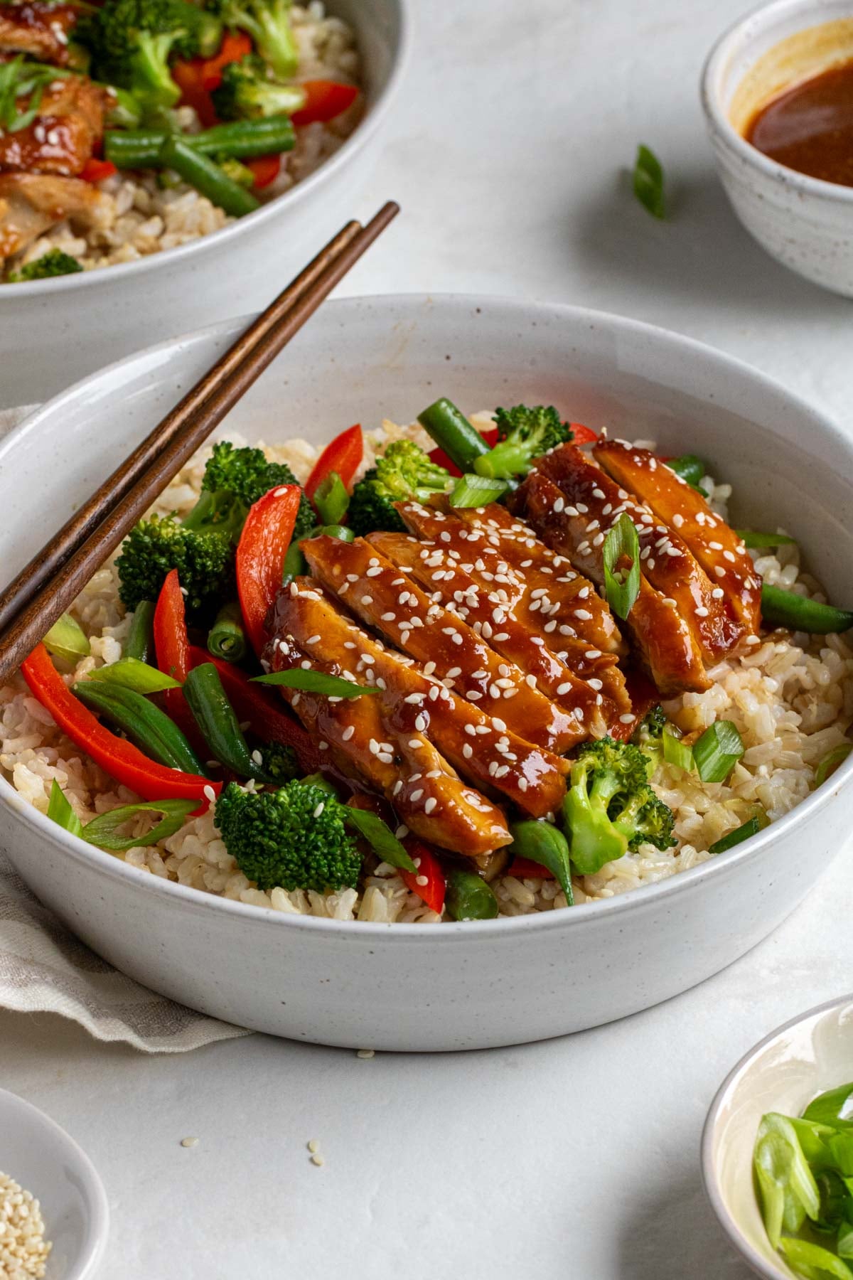Close up of a teriyaki chicken rice bowl with sesame seeds on top.