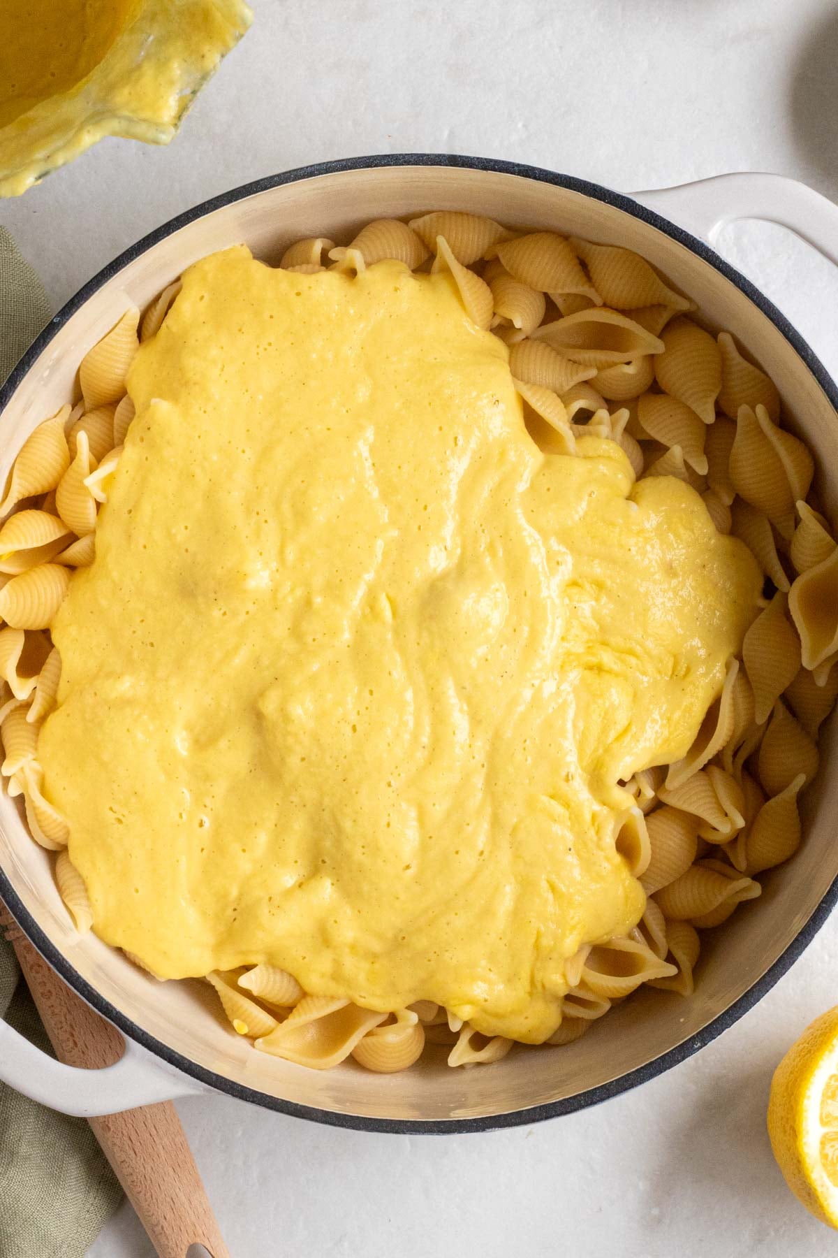 Large pot of cooked shell pasta with creamy corn pasta sauce on top.