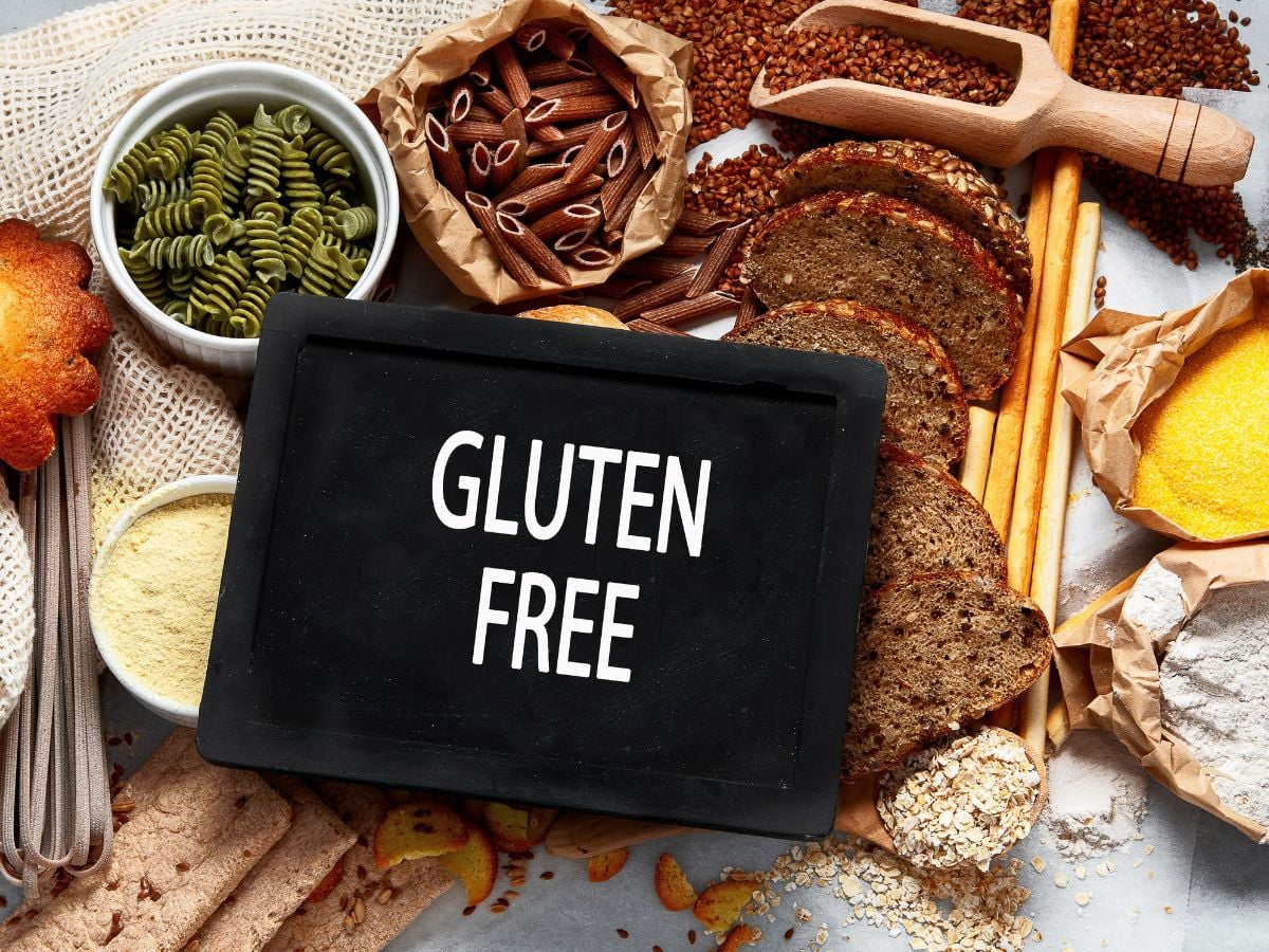 Chalkboard with the word gluten-free surrounded by gluten-free pasta, flour, bread, and buckwheat.