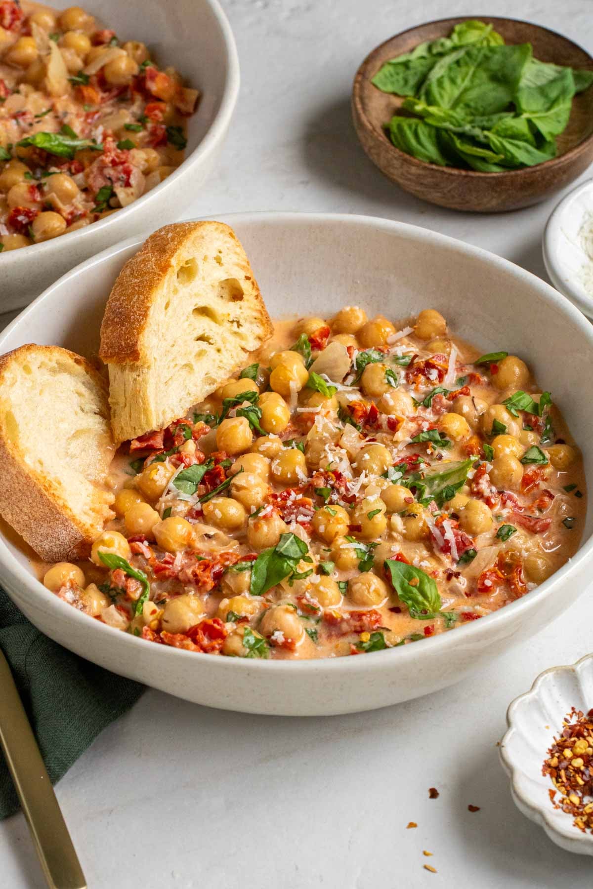 Close up of a bowl of marry me chickpeas with a slice of toasted bread.