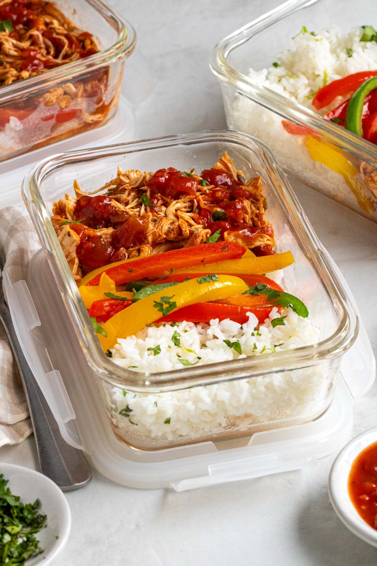 Close up of glass meal prep containers of salsa chicken bowls.